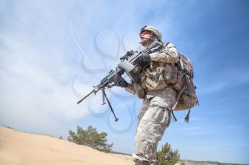 Portrait of United states airborne infantry machinegunner, camo uniforms dress. Combat helmet low angle, front view