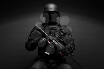 Spec ops police officer SWAT in black uniform studio 