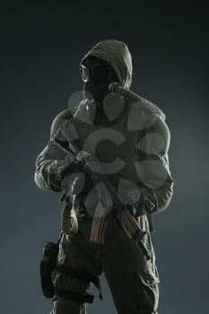 Nuclear post apocalypse. Studio shot of survivor with weapons and gas mask