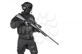 Studio shot of swat operator with sniper rifle wearing black uniforms. Tactical helmet gloves, eyewear and telescopic sight. Security forces protecting