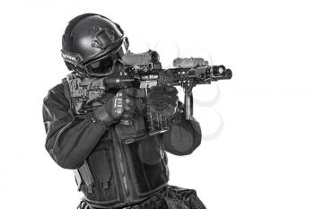 Studio shot of swat police special forces automatic rifle black uniforms aiming criminals. Tactical helmet vest goggles. Isolated on white side view