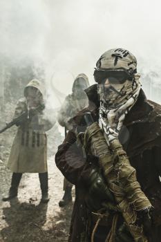 Nuclear post-apocalypse. Survivors in tatters and gas mask on the ruins of the destroyed city