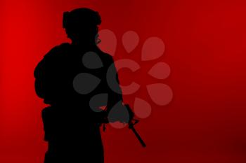 United states Marine Corps special operations command Marsoc raider with weapon. Silhouette of of Marine Special Operator red background