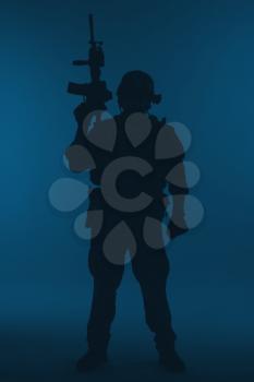 United states Marine Corps special operations command Marsoc raider with weapon. Silhouette of of Marine Special Operator blue background full body