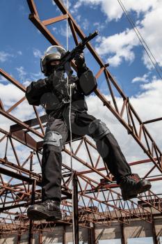 Special forces operator during assault rappeling with weapons