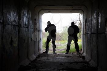 Silhouette of special forces operators with weapons in the tunnel