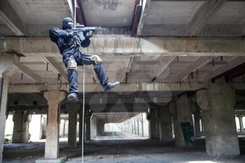 Special forces operator during assault rappeling with weapons
