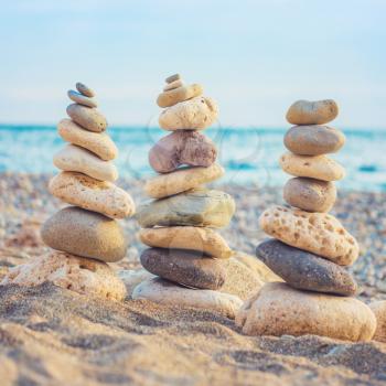 Three stacks of round smooth stones on the beach