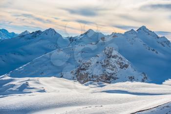 Snowy blue mountains in clouds. Winter ski resort