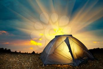 Illuminated yellow camping tent under stars at night. Instagram like filter