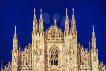 Night view of famous Milan Cathedral (Duomo di Milano) on piazza in Milan, Italy with stars on the blue dark sky