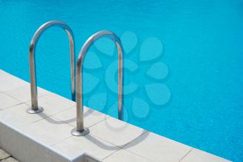 Swimming pool with stair and blue relaxing water