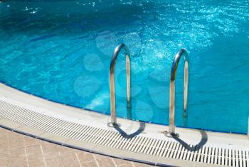 Swimming pool with stair and blue relaxing water