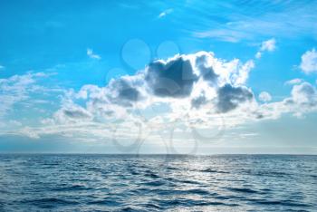 Sea with blue water, sky and clouds. Sunset above seascape 