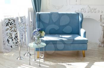 Light interior in the fusion style with velvet sofa of the sea wave color.