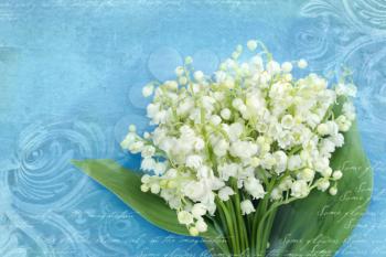 Bouquet of lilies of the valley on a grunge blue background with architectural details meander, capitals, friezes. Art deco figures carved on stone. Fragment of ornate relief with flowers.