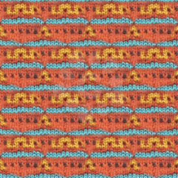 Knitted woolen seamless pattern. Beautiful red, blue, yellow knit texture for textile. Repeating abstract background. 