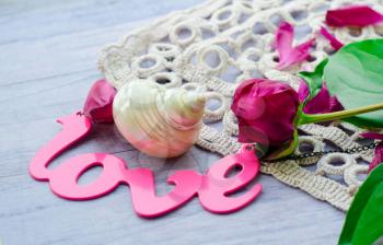 Beautiful fresh peoniesand and some decorations on wooden surface.