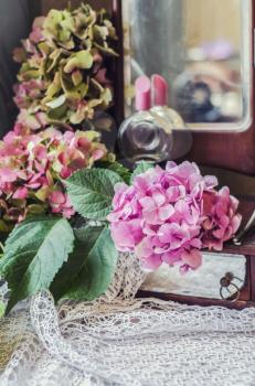 Still life of hydrangea, ancient mirror on knitted crocheted napkin. Vintage composition in the style of chebbishik.