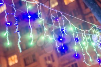New year garlands on the blurred background of city houses.Urban Christmas photo.