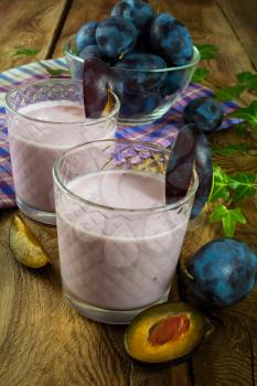 Plum smoothies, prune yogurt, fruit diet healthy drink in a glass on a dark wooden background, close up. Selective focus