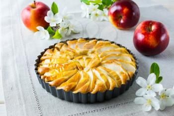 Apple pie and apple blossom on the linen napkin. Homemade apple cake. Sweet pastry. Homemade dessert. Apple pie.