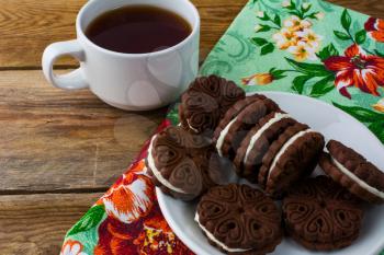 Chocolate cookies sandviches and cup of tea. Sweet dessert. Homemade biscuit. Breakfast cookies