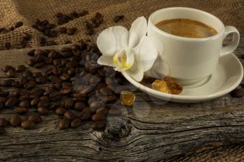 Coffee cup and white orchid on the wooden background. Coffee break. Morning coffee. Cup of coffee. Coffee cup. Coffee