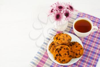Homemade cookies and cup of tea on checkered napkin. Sweet dessert. Homemade biscuit. Breakfast cookies. Tea cup. Homemade cookies. Tea time. 
