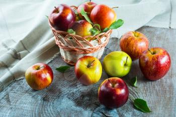 Ripe apples in the basket on the wooden table. Fresh fruits. Fresh apples. Healthy food. Healthy eating. Vegetarian food. Healthy eating concept. 