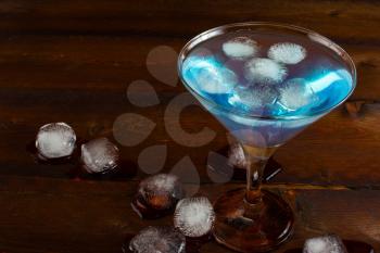 Iced blue cocktail on wooden background. Blue margarita. Blue cosmopolitan. Blue Lagoon. Blue cocktail. Blue Martini. Blue Hawaiian cocktail. Blue curacao liqueur.