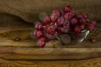 Bunch of red grapes on a dark wooden background. Cluster of grapes. Bunch of grapes. Cluster grapes.  Bunch grapes. Grapes. Grape