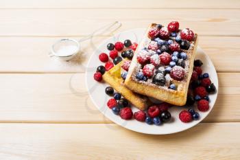 Belgian waffles with blueberry, raspberry and ising sugar. Breakfast soft waffles with fresh berries. 