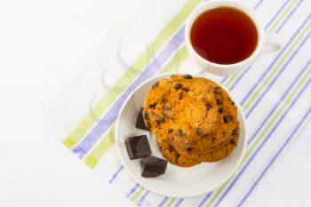 Cup of tea with chocolate chip cookies and dark chocolate.  Breakfast cookies and tea cup. Tea time with cookies.