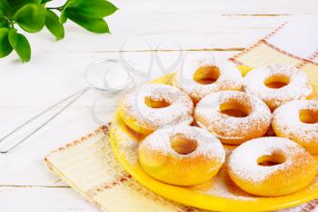 Donuts with caster sugar served on yellow plate. Sweet dessert pastry doughnuts.   