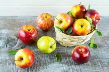 Fresh apples in the  basket on the rustic background. Ripe  fruits as vegetarian food concept. Healthy eating concept with fresh fruits.