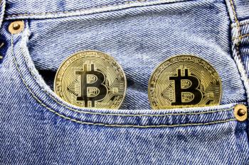 Two golden bitcoin coins on the pockets of the jeans. Concept of making money with online business. Making money motivational message. Online making money with bitcoin.