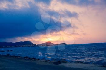 Sunset Sea Perspective from the Shoreline, Beautiful Mountain Ocean view Landscape, Shimmering Twilight with blue and dark colors, Hidding Sun between Cloudy Sky