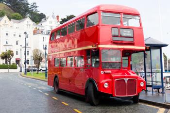 LLandudno, Wales, UK - MAY 27, 2018 London's red double decker car parked on the road. buses on the stop. Tourism and touristic travel with legendary double decker bus. Red transport vehicle