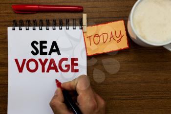 Text sign showing Sea Voyage. Conceptual photo riding on boat through oceans usually for coast countries Man holding marker notebook clothespin reminder wooden table cup coffee
