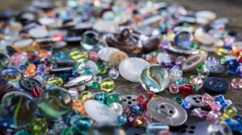 A group of randomly scattered beads, buttons and marbles