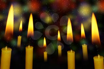 Wax yellow candle on abstract dark background.