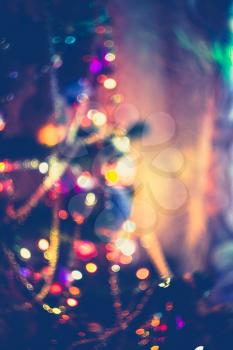 Decorated Christmas tree and colorful garland lights, defocused background, bokeh effect.