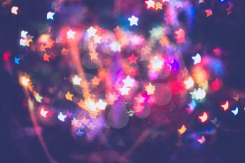 Festive background with star shaped bokeh from Christmas tree lights glowing. 