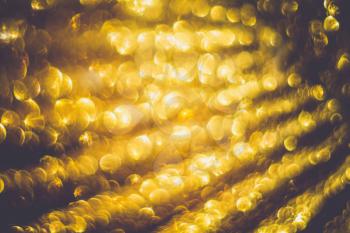 Festive background with defocused golden glitters, bokeh effect.