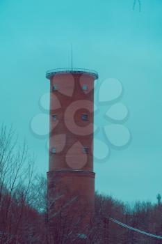 Vintage style red brick water tower of an old factory, filtered.