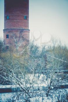Vintage style red brick water tower of an old factory, filtered.