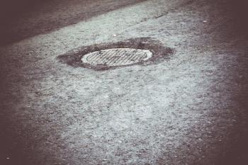 Sewer manhole cover on the new asphalt urban road.