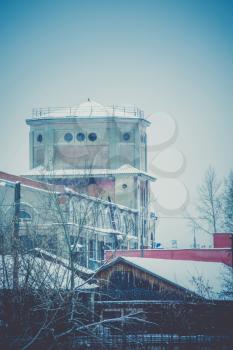 Vintage style red brick building, old factory, filtered winter time landscape.