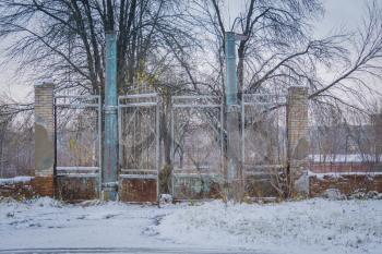 Grunge old broken metal gate, abandoned rural stadium, winter scene.